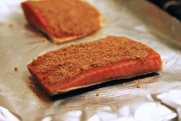 Wild Sockeye Salmon is seen on a foil covered baking sheet with a brown powdery coating on top. Broiling is the best way to cook sockeye salmon.