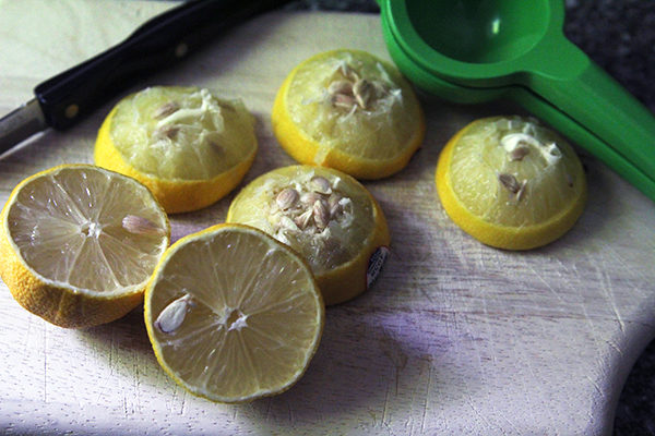 Juiced lemons sit on a cutting board.