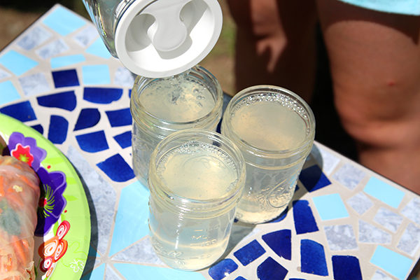 Homemade lemonade is poured into mason jar glasses.