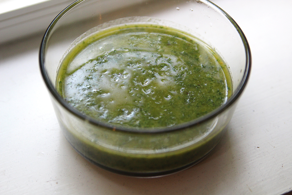 Carrot Top Chimichurri sauce is shown in a glass bowl on a white surface