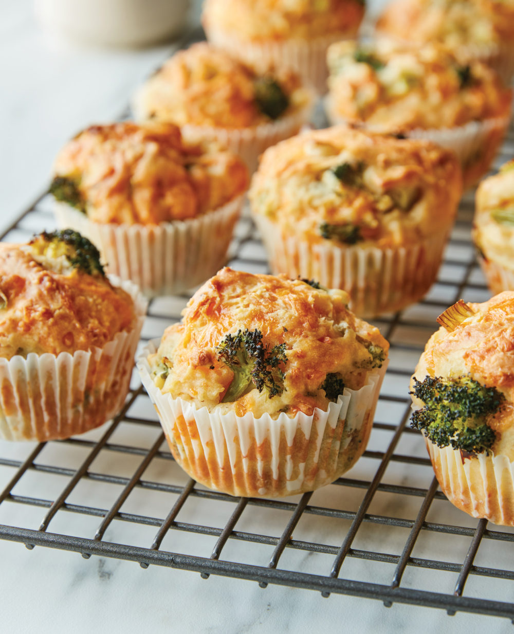 Broccoli Cheddar Muffins are shown on a wire rack.