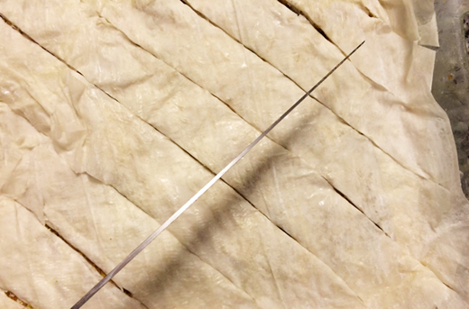 A nut cutting cross-hatches in phyllo dough