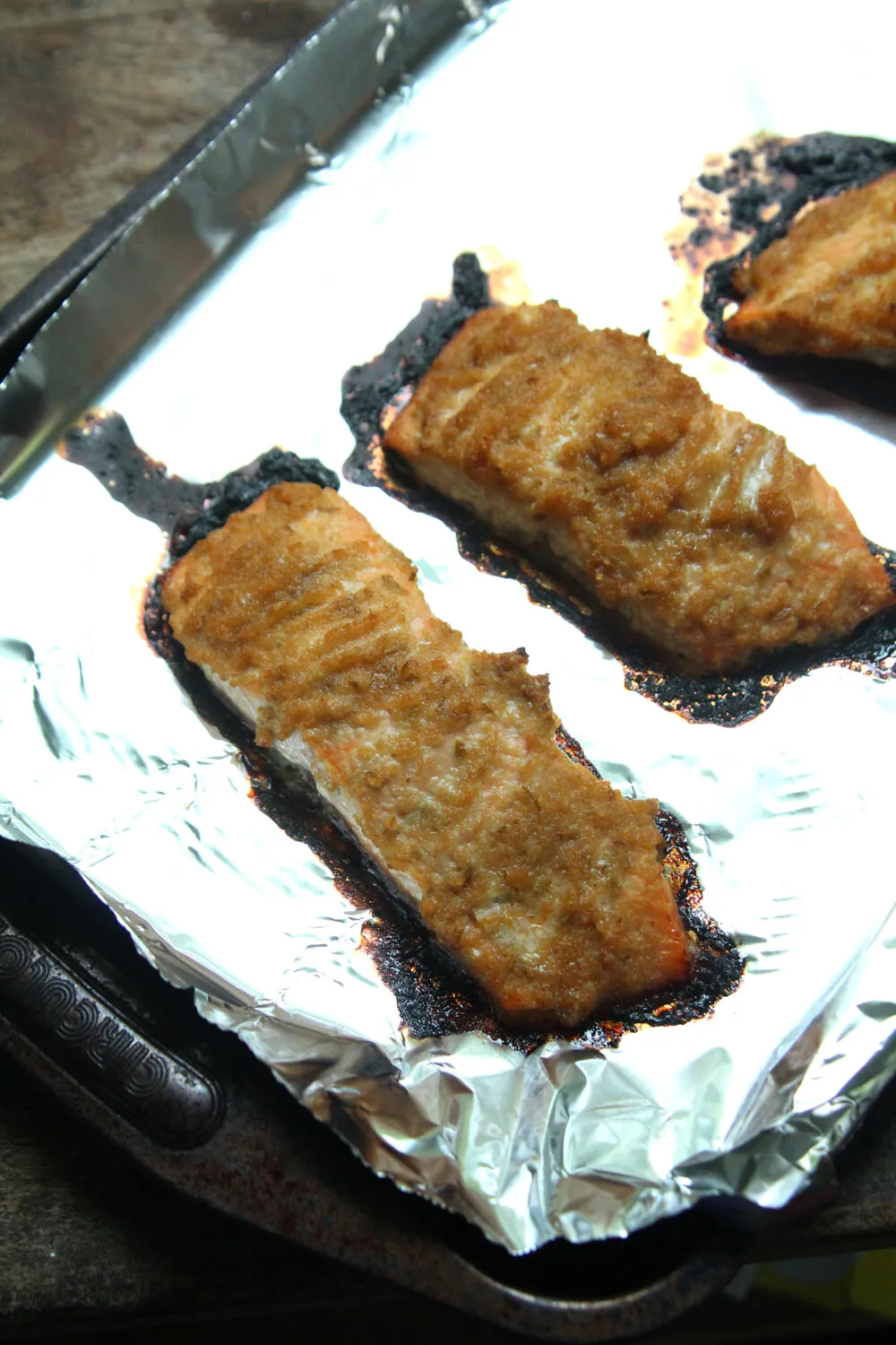 Cooked Salmon Bulgogi fillets are shown on a foil-lined baking sheet. 