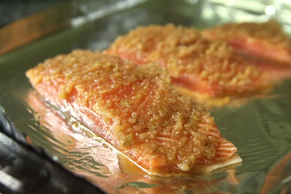Uncooked Salmon Bulgogi fillets are shown on a foil-lined baking sheet. 