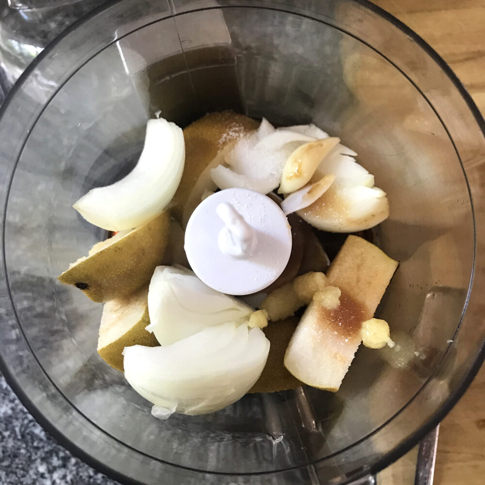 Asian pear, onion, soy sauce, ginger, garlic and sugar are shown in a small food processor.