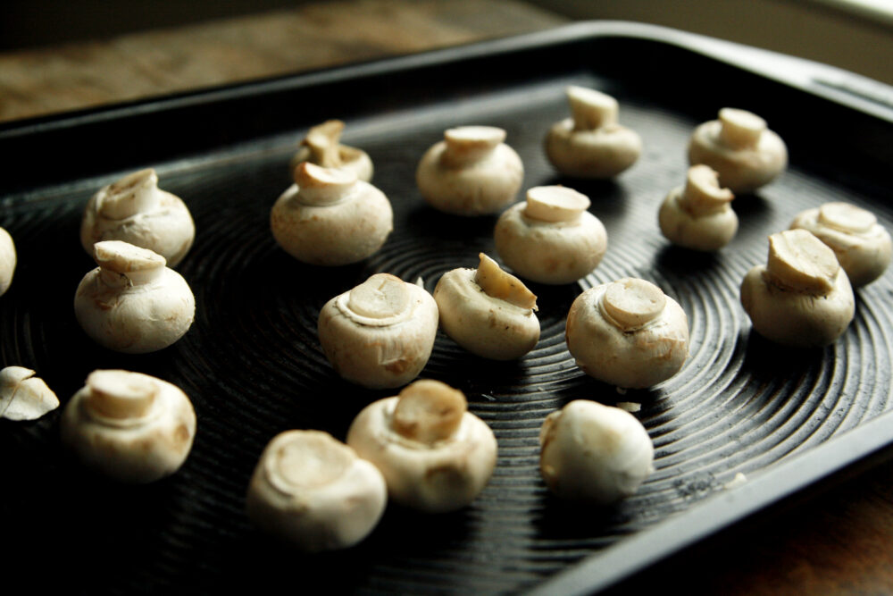 Cleaned mushrooms sit on a baking sheet.